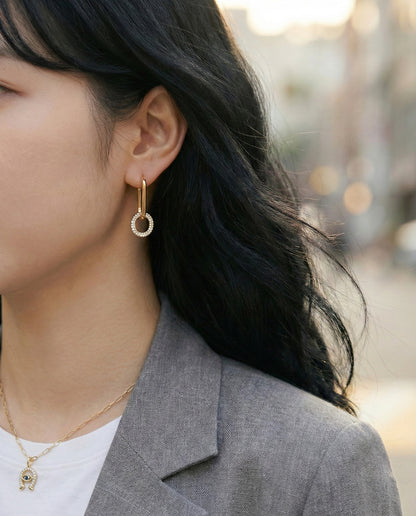 Gold oval link drop earrings worn with gray blazer and white tee, office look