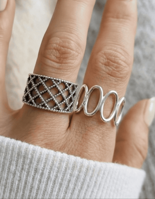 Model wearing 925 sterling silver oval loop ring and lace lattice ring together on two fingers, white ribbed knit sleeve, mix-and-match bold ring stack