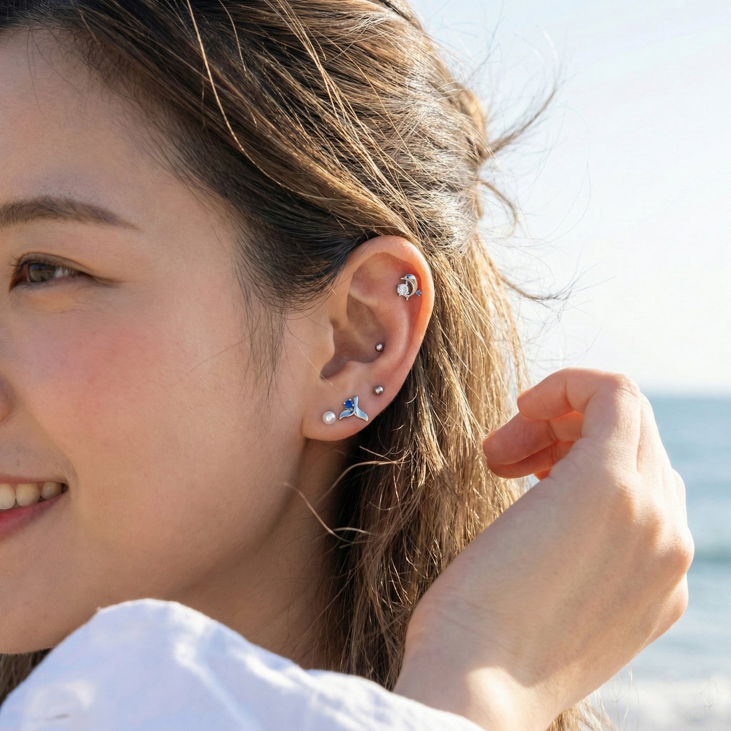 Full ear view wearing silver option dolphin whale tail piercing set from inner conch to lobe