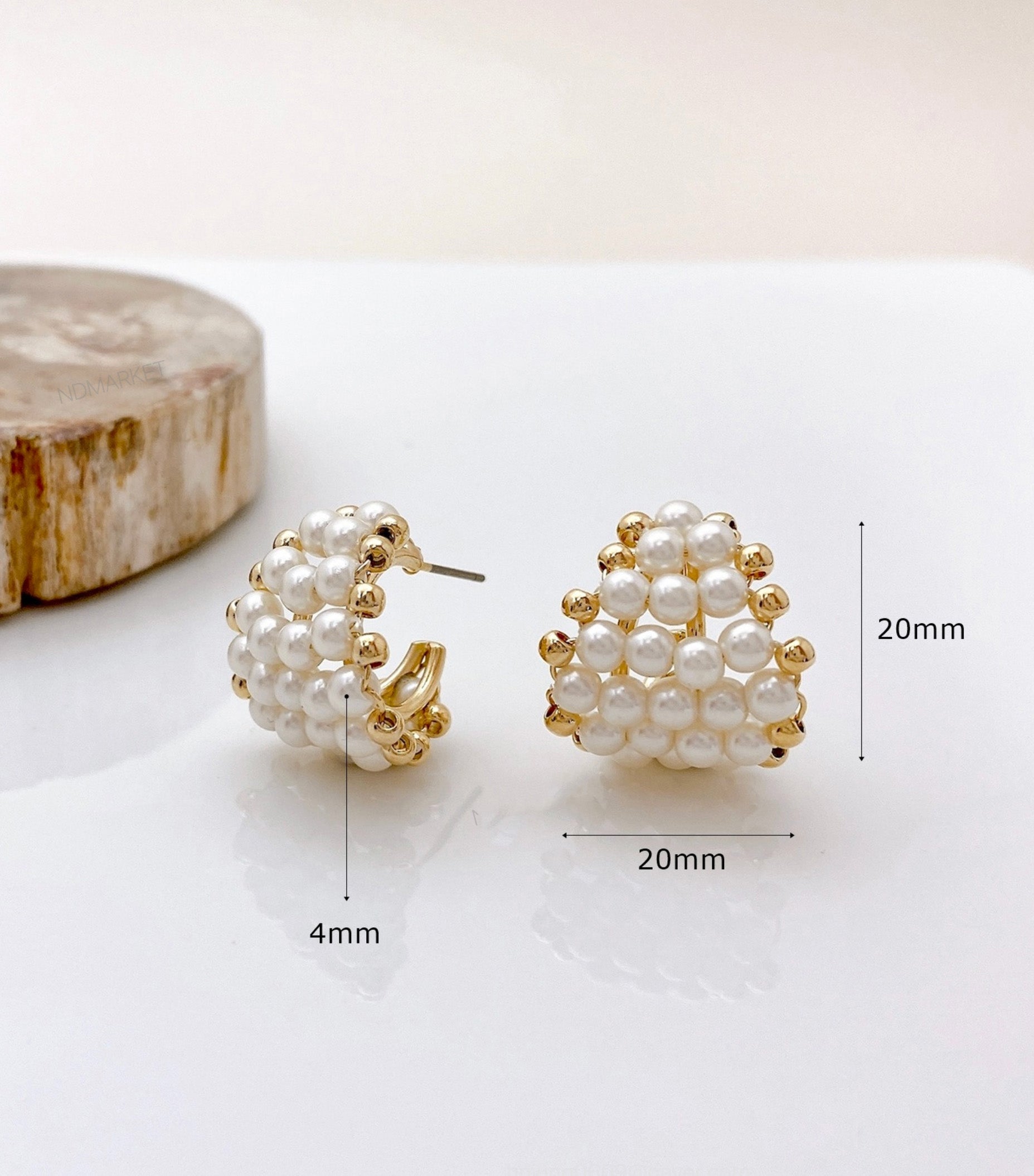 Size reference of pearl heart hoop earrings on wood - 20mm measurement shown