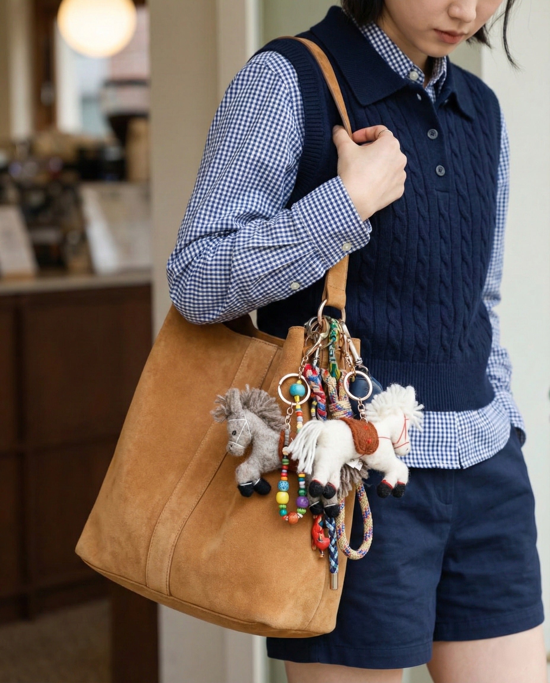 Handmade pony bag charms on shoulder bag with gingham shirt and navy vest casual outfit