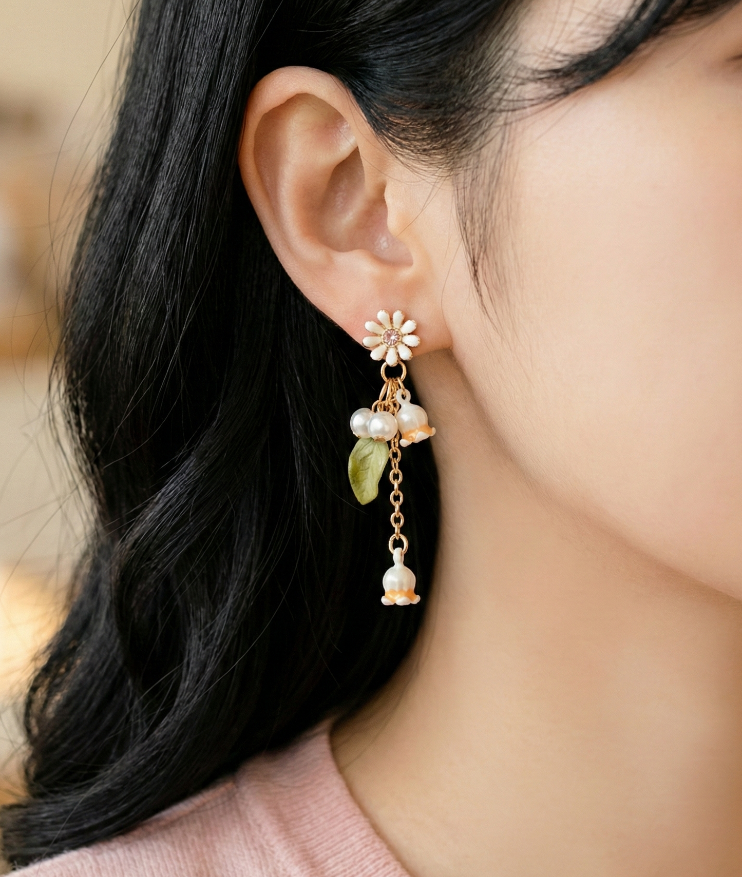 Detailed macro shot of the white flower bells, faux pearls, and leaf charm.