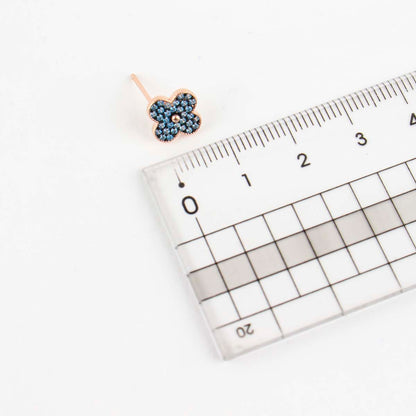 Size reference of aqua blue clover stud earring next to ruler showing 1cm diameter