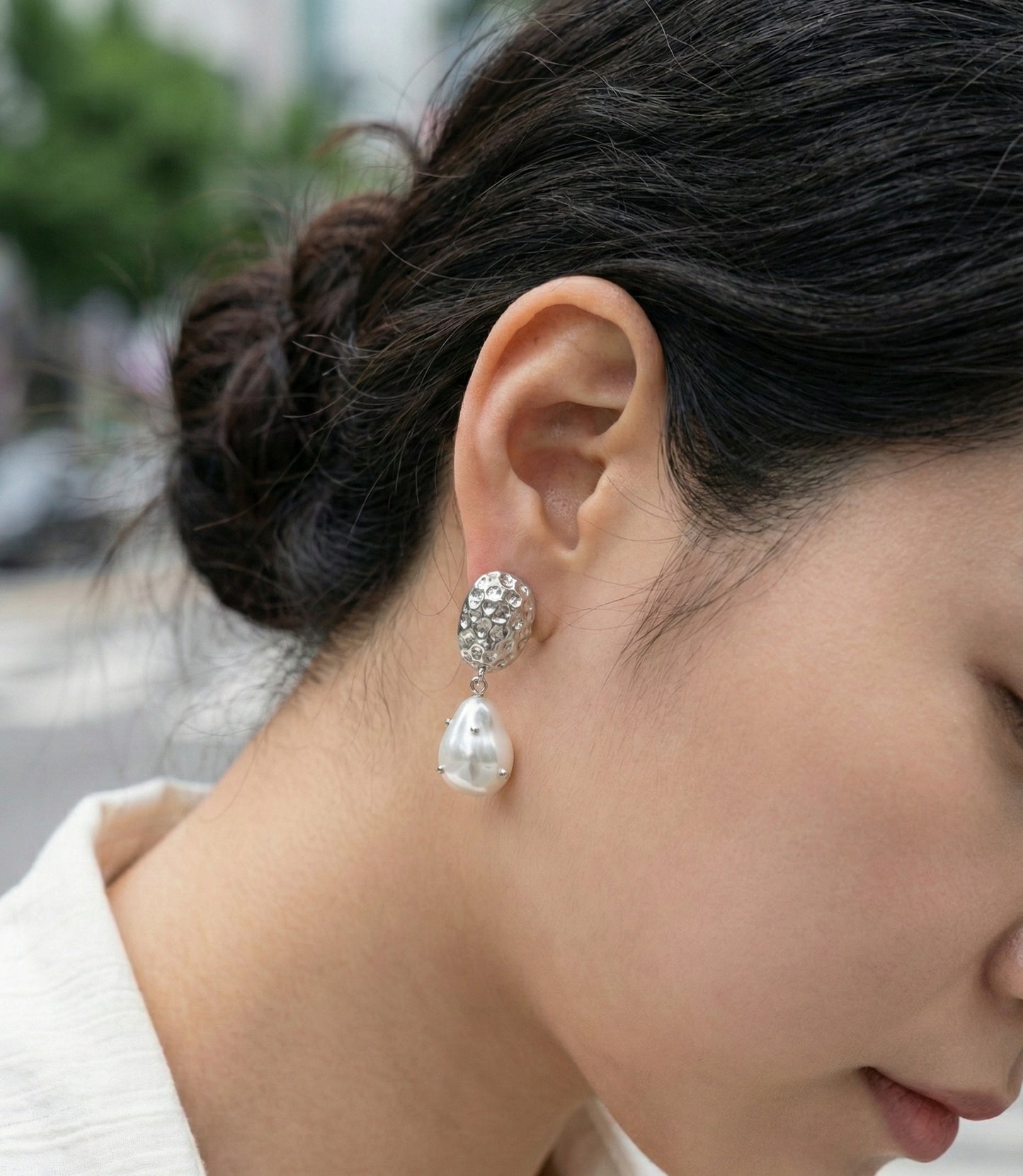 Model wearing gold vintage baroque pearl drop earrings outdoors
