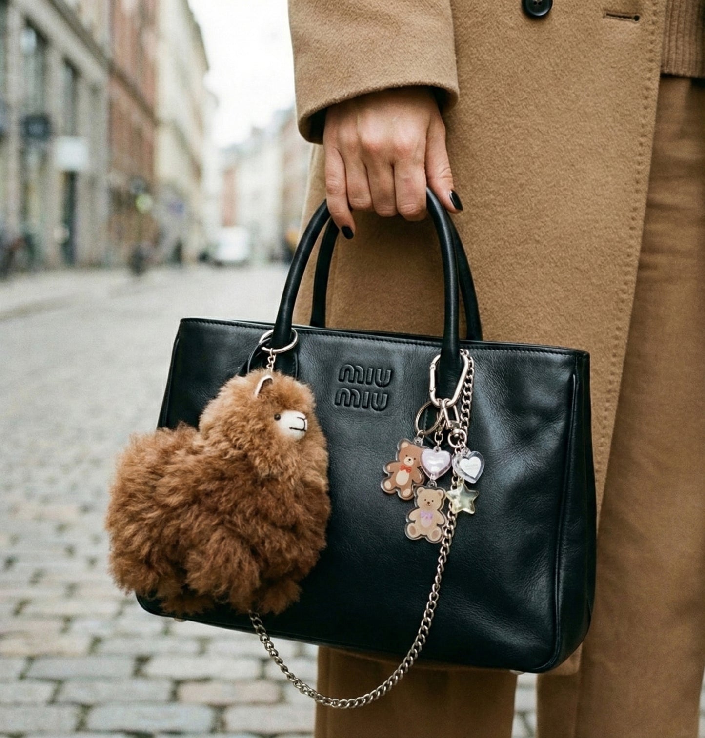 Camel beige alpaca fur keychain layered with colorful charms on wine-colored canvas tote bag, winter street fashion