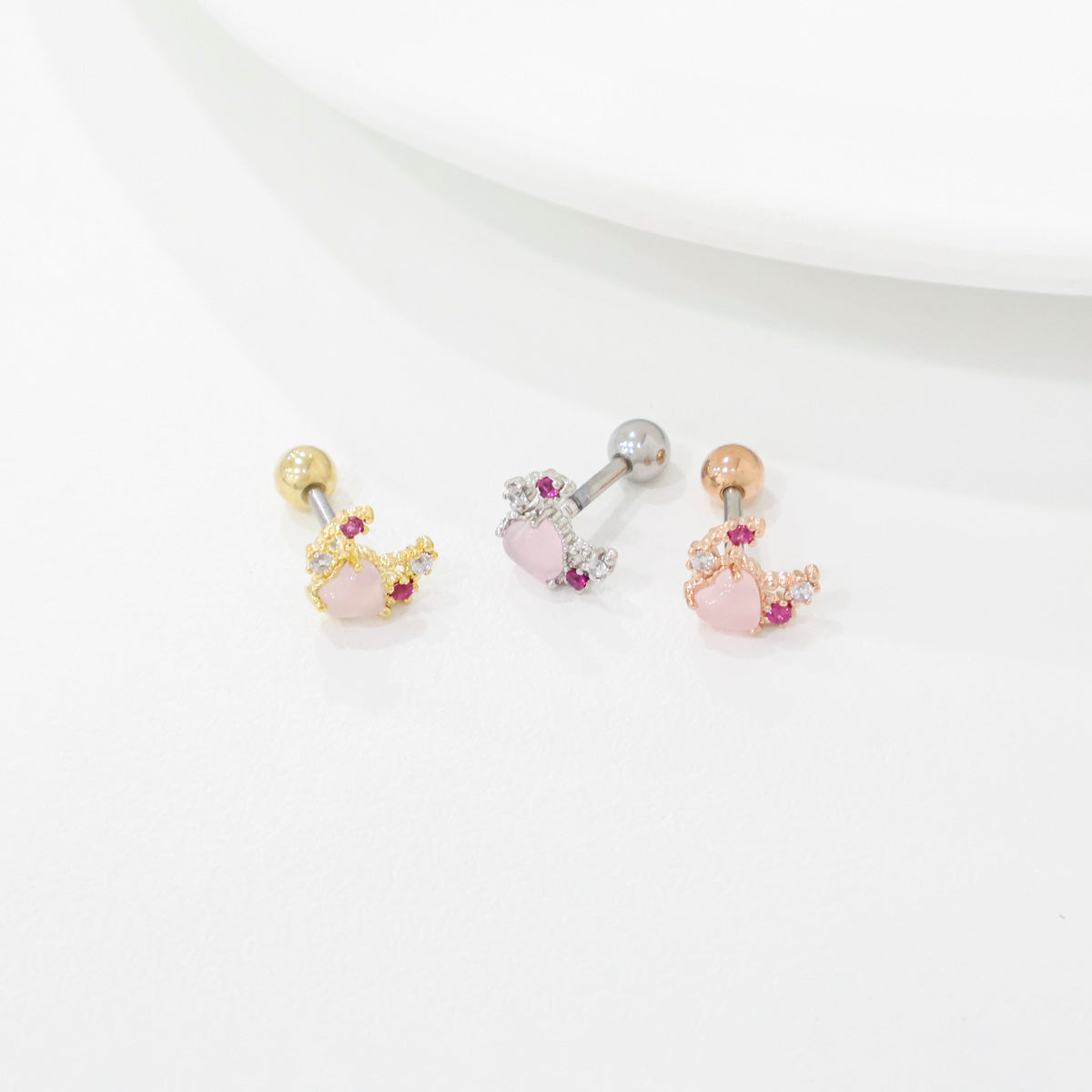 Three moon heart barbell studs with surgical steel post and pearl ball closure on white background