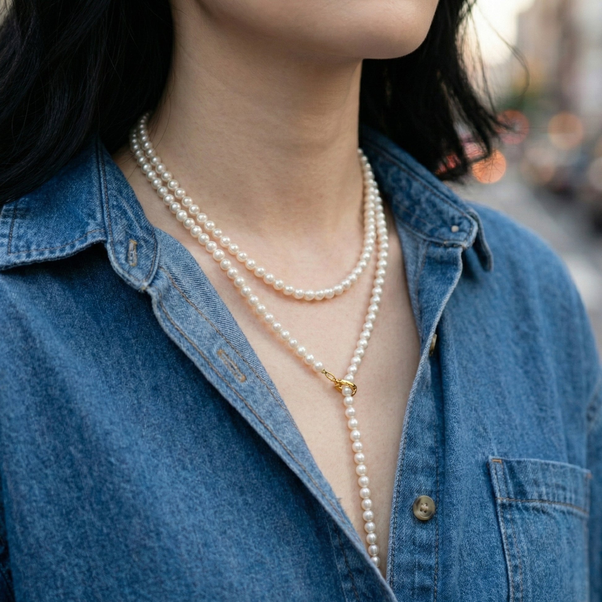 Detail shot of pearl necklace gold hook clasp and layering technique