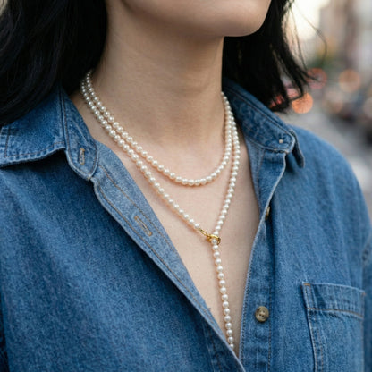 Detail shot of pearl necklace gold hook clasp and layering technique