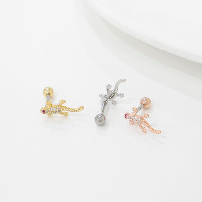 Three lizard-shaped earrings on a light gray background