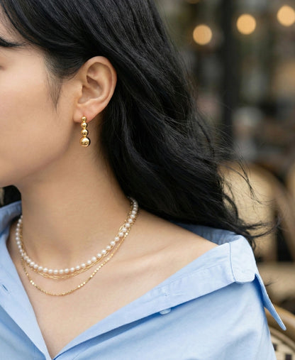 Front view of silver 4-tier sphere bar earrings with structured linear silhouette