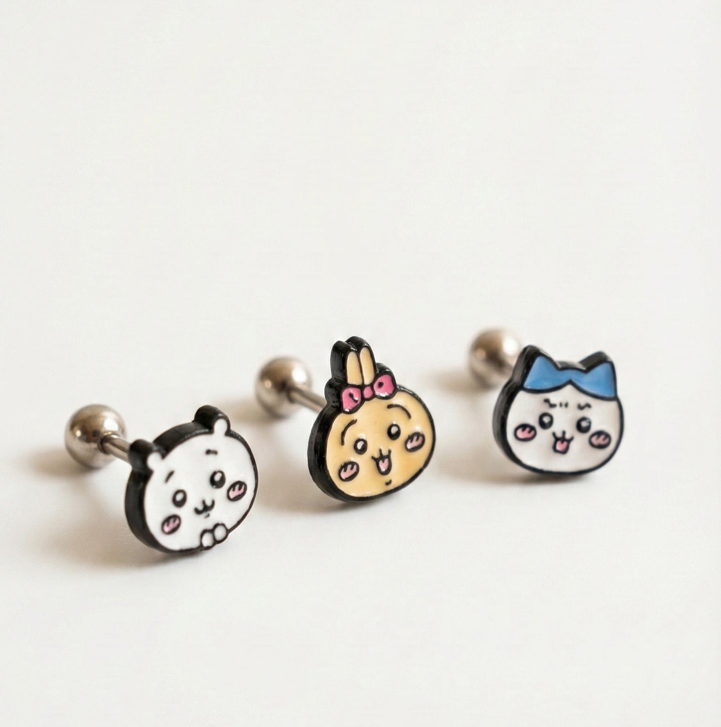 Three cartoon-style earrings on a white background