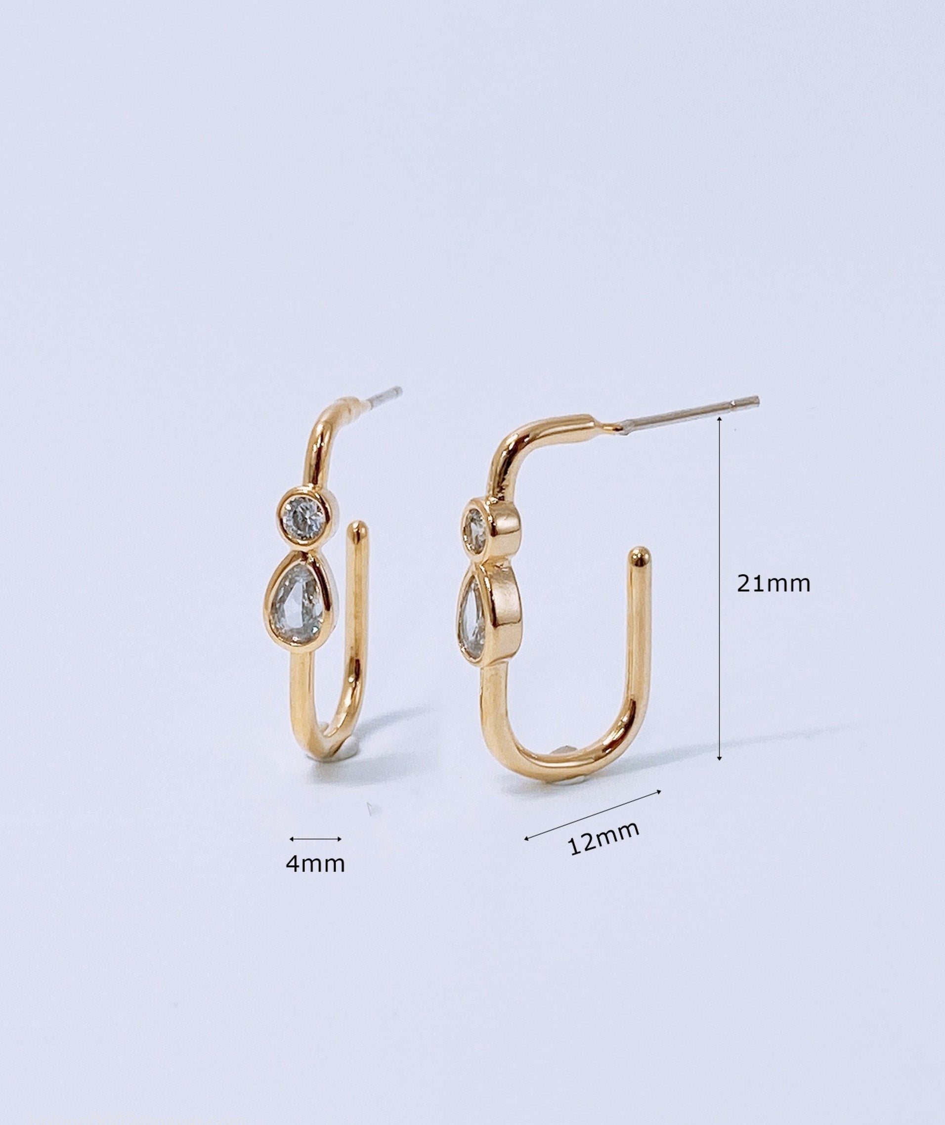 Product dimension measurement of gold bezel-set U-hoop earrings showing 21mm height and 12mm width with titanium post