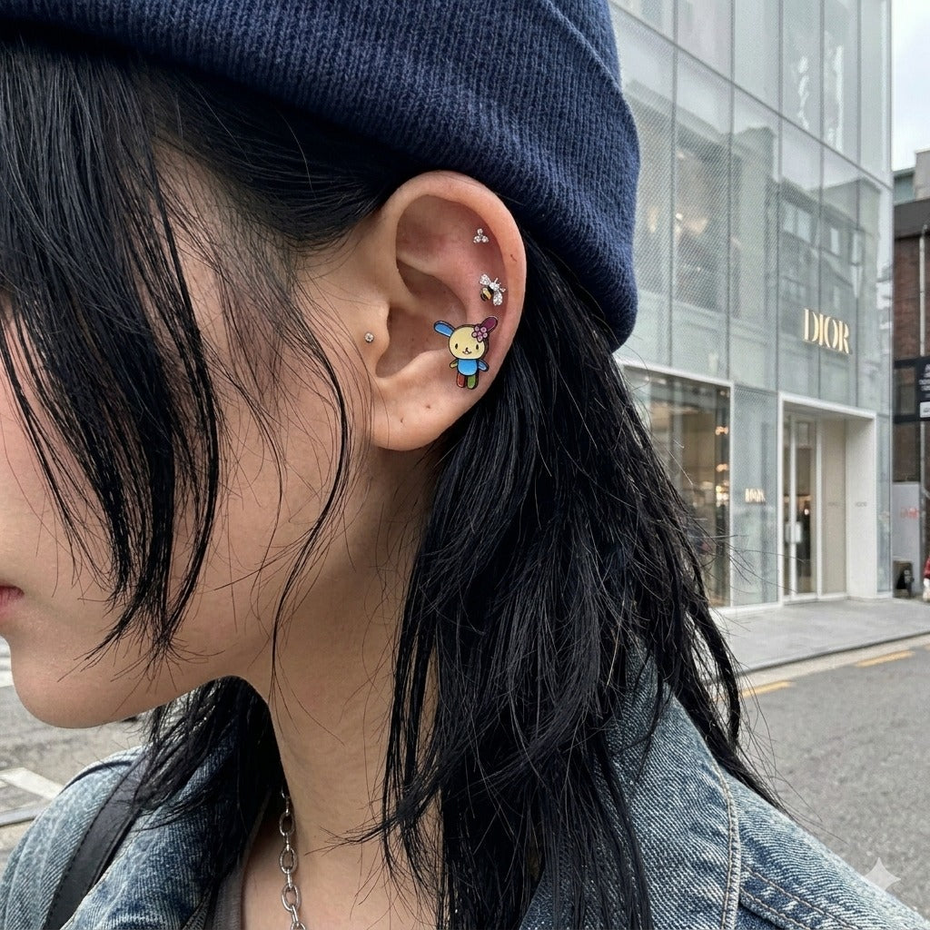 Y2K mismatch ear stack bumblebee CZ piercing with kawaii character stud, Stussy beanie Seoul street style earscape.