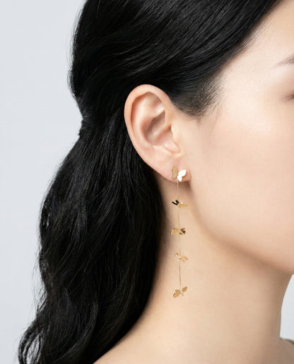 Gold butterfly long chain drop earrings on model showing movement