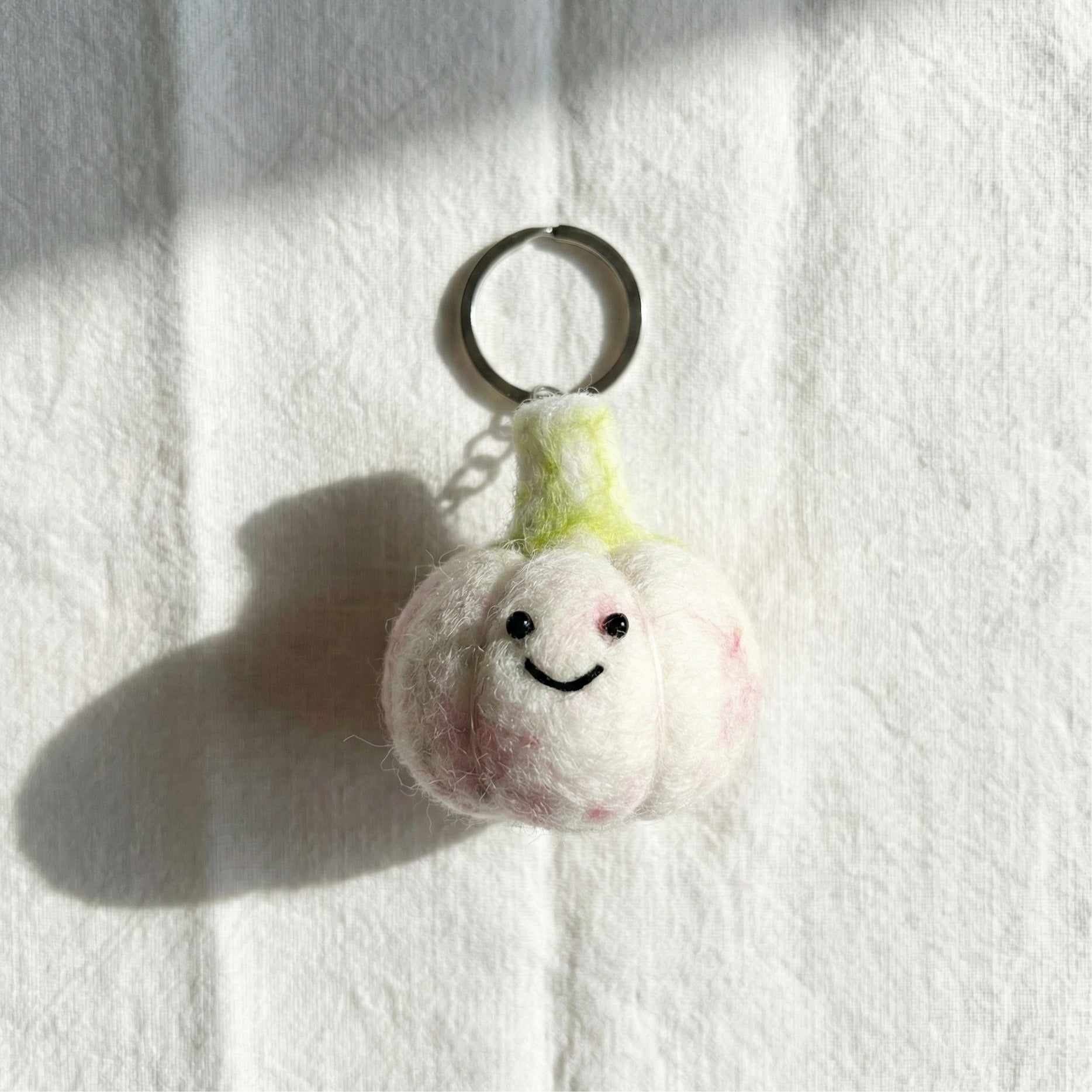 White garlic felt keychain with pink cheeks and happy smile