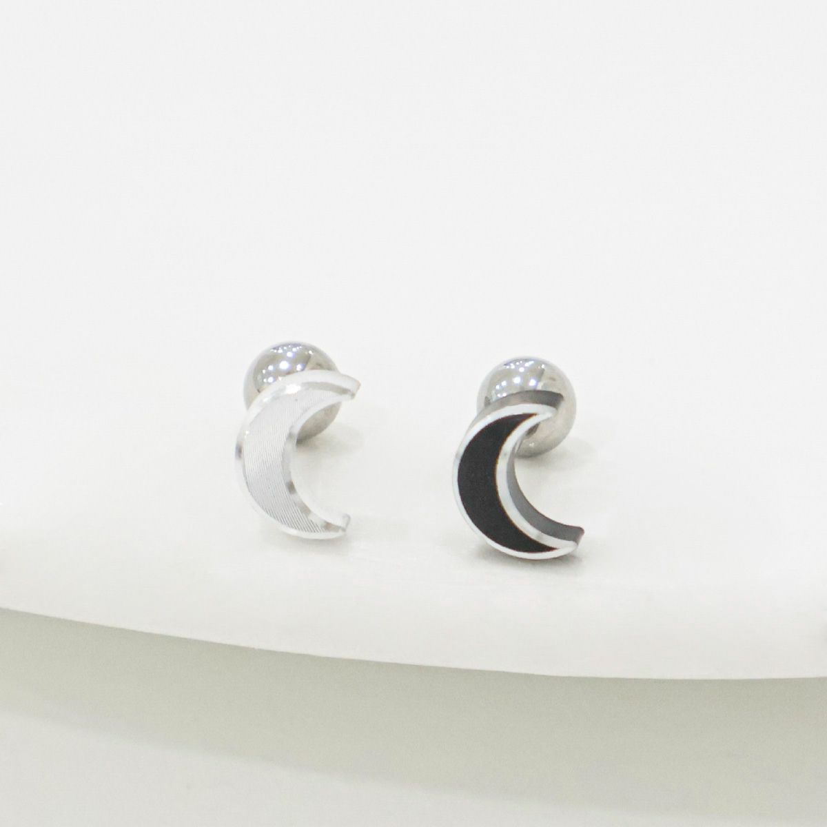 Silver crescent moon barbell stud earrings on white background