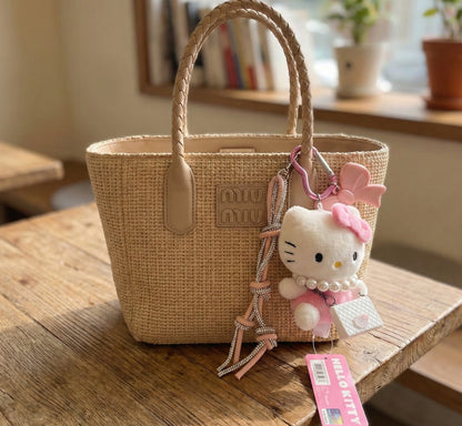 Hello Kitty plush keychain with quilted mini bag and crystal rope strap displayed on marble cafe table — coquette aesthetic accessory