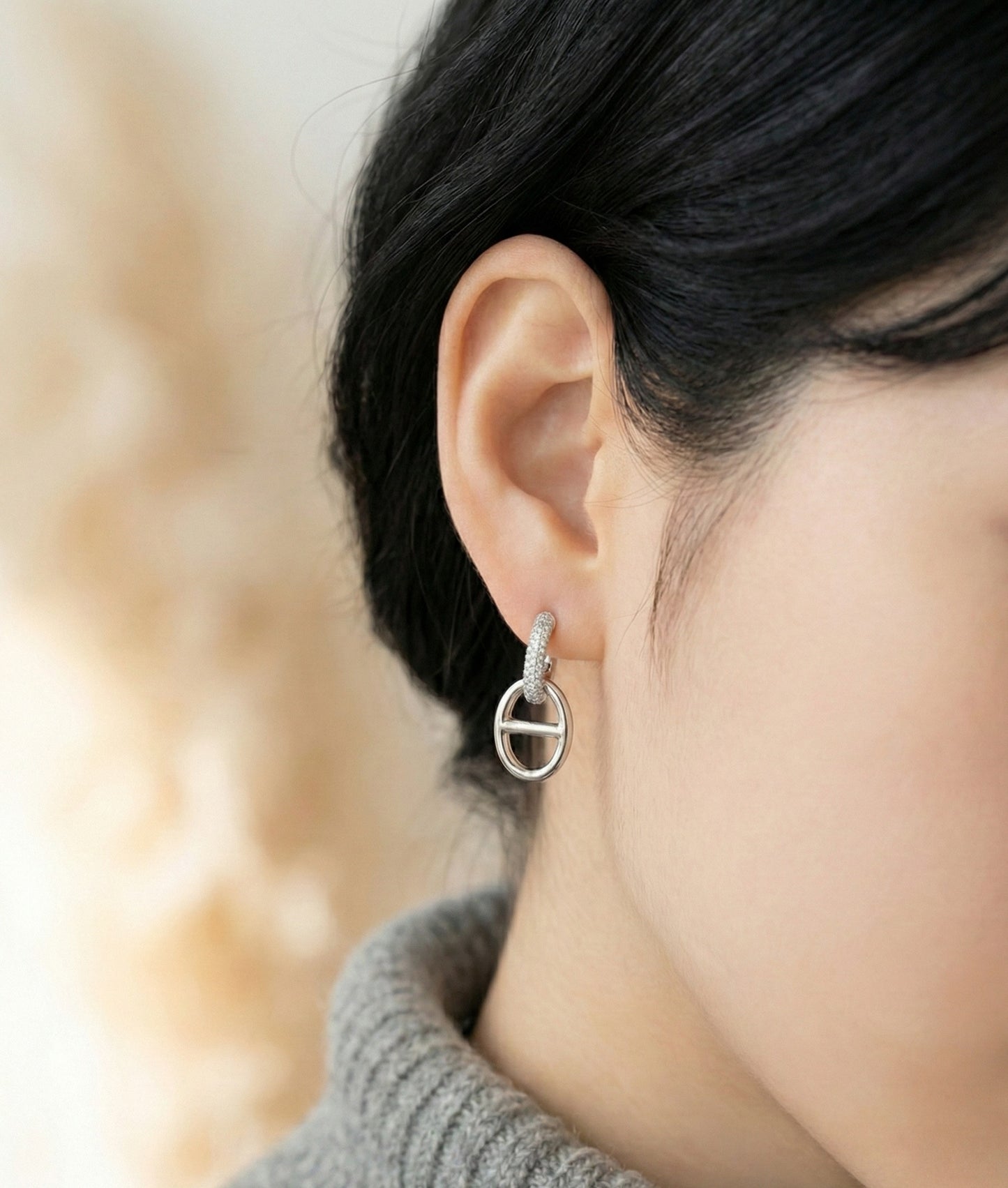 Model wearing silver huggie drop earrings showing elegant drape