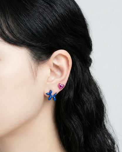 Model wearing rose gold balloon dog earring with love heart charm showing layered ear styling