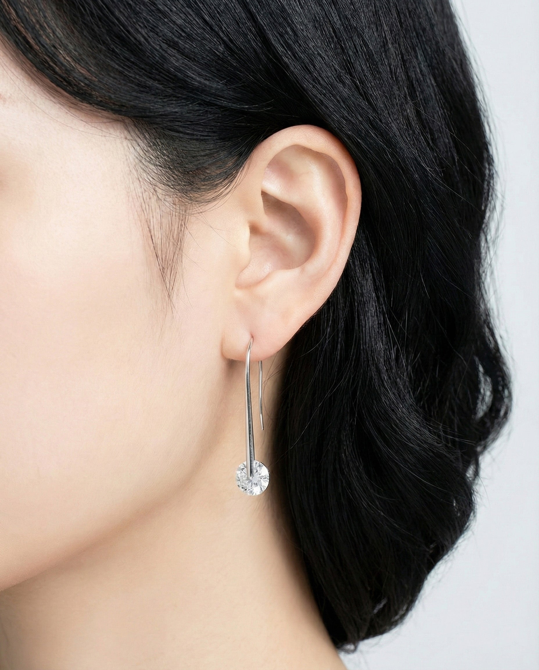 Profile shot of model with silver 43mm U-hook drop earrings showing face-slimming effect