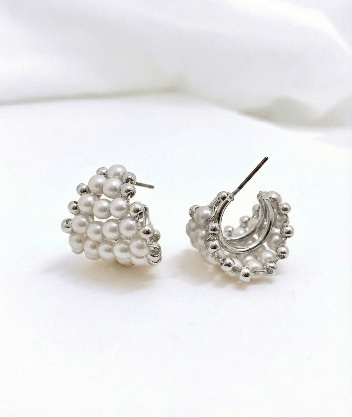 Silver pearl heart C-hoop earrings with titanium posts on white background