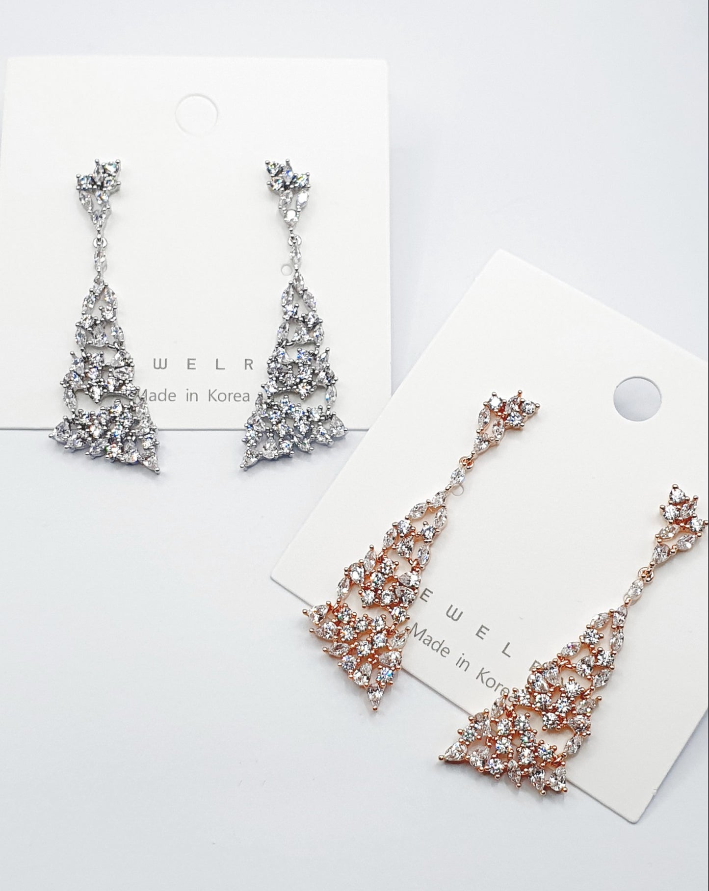 Comparison of silver and rose gold chandelier drop earrings on cards