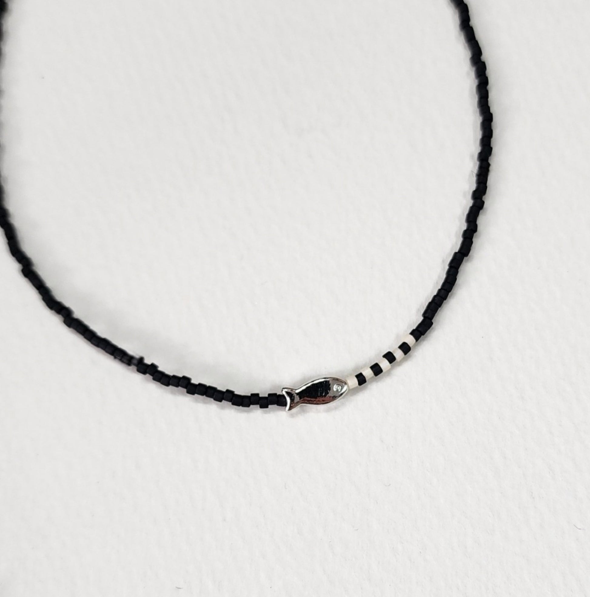 Deep black seed bead choker with silver fish pendant and white accent beads elegant style