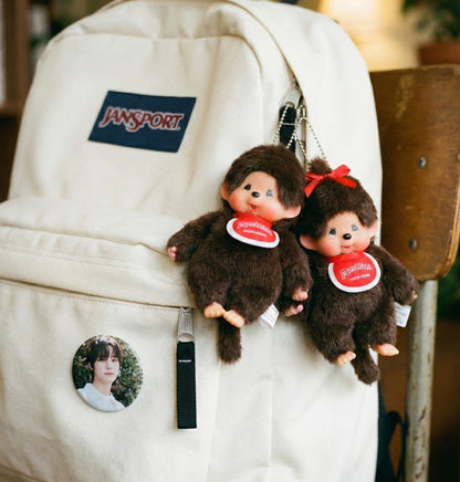  Monchhichi Classic Boy and Ribbon Girl keychains on cream JanSport backpack with K-pop photocard button — Y2K schoolcore aesthetic