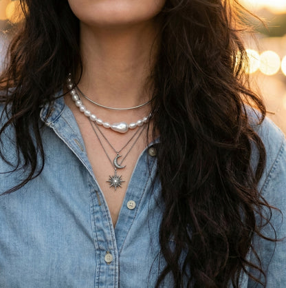 Layered pearl necklace styling with moon and star pendant on casual outfit