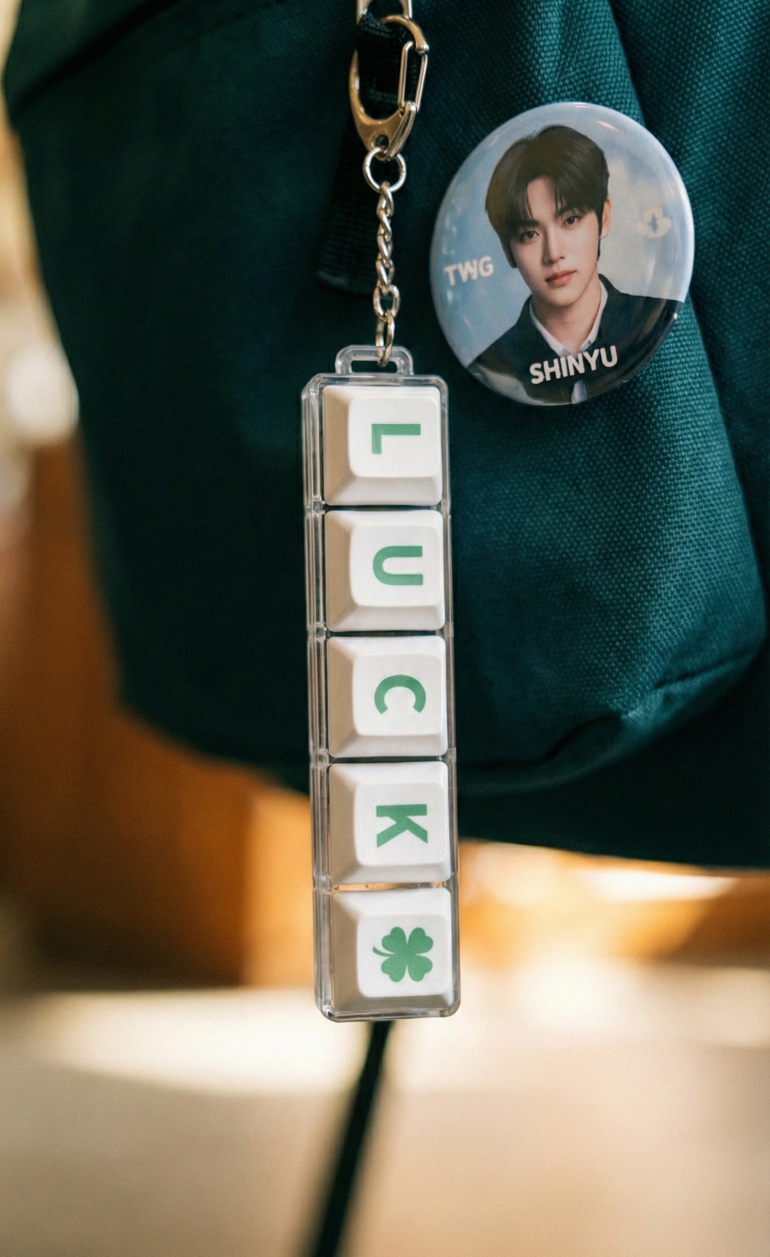 Side view of person wearing backpack with LUCK keychain and photocard charm