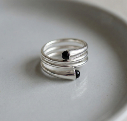 925 sterling silver spiral wrap black onyx rings displayed side by side on white ceramic dish
