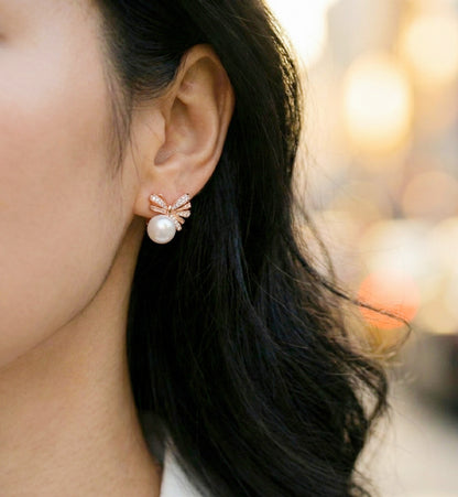 Woman wearing rose gold pearl bow earrings with white shirt, office look styling
