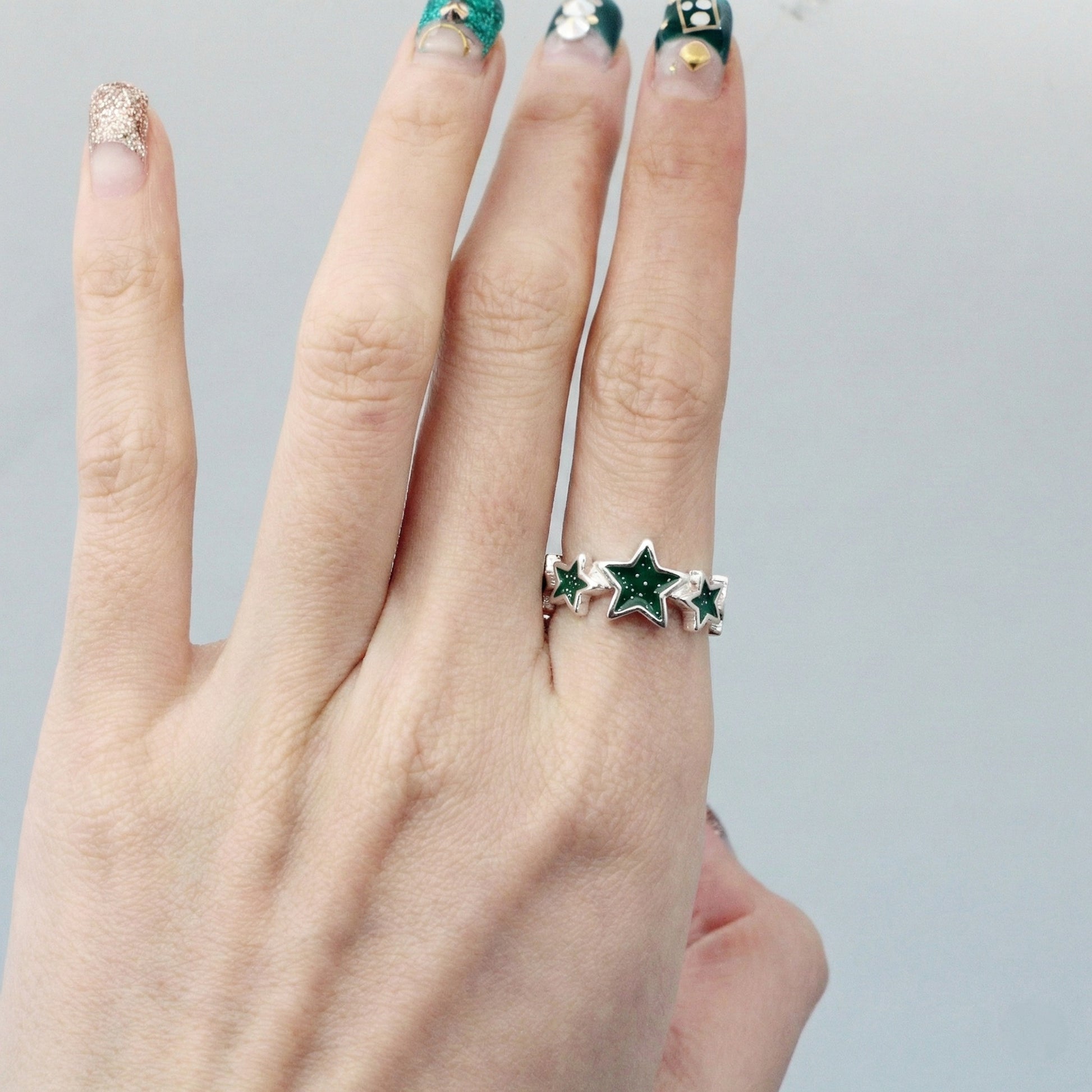 Glitter star ring on finger with colorful nail art demonstrating Y2K aesthetic