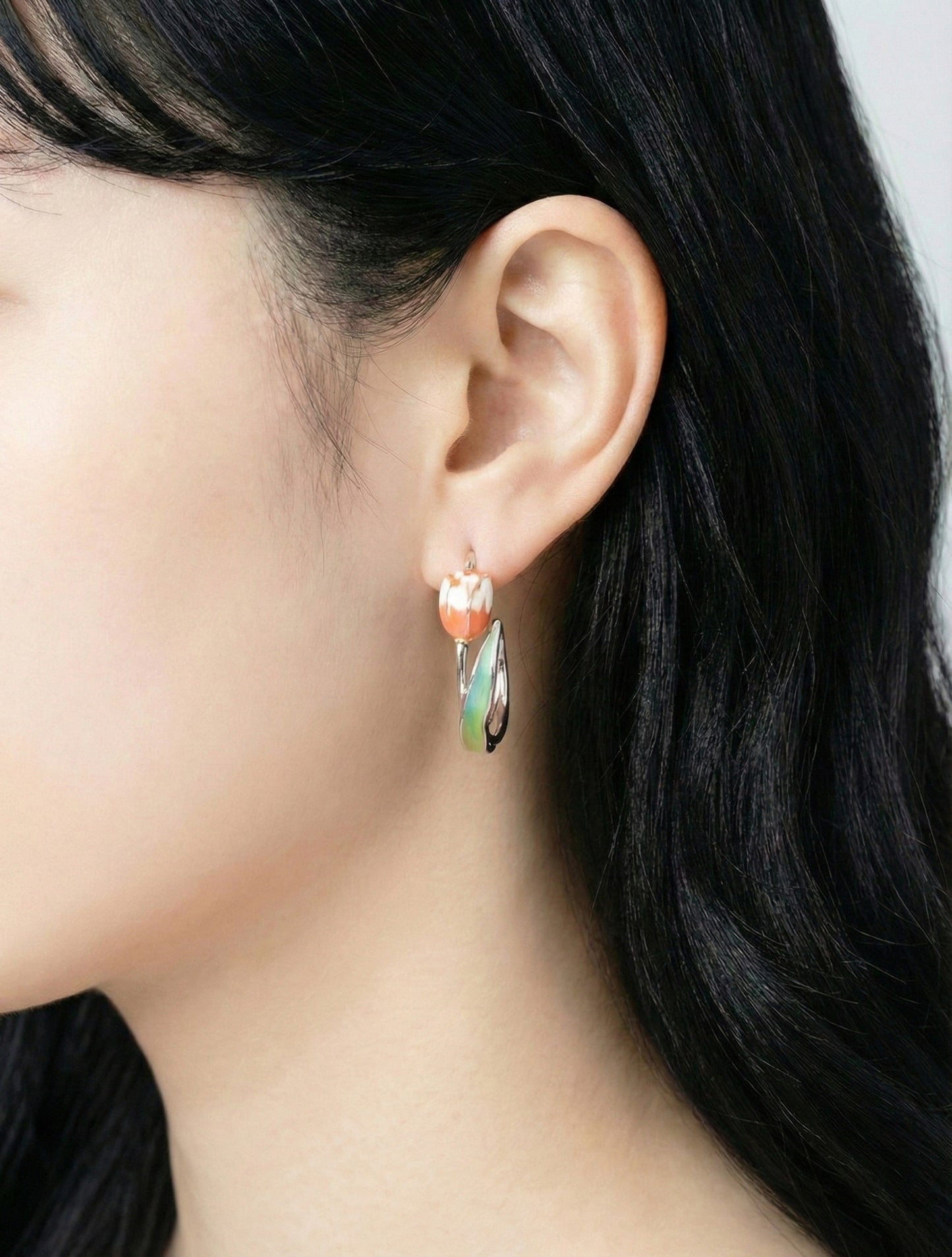 Woman modeling pink watercolor tulip hoop earrings for spring outfit