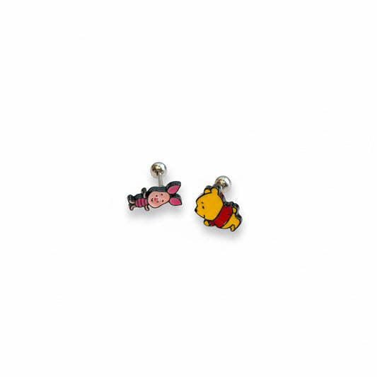 Woman wearing Winnie the Pooh cartilage earring and Piglet lobe earring with Pooh collectibles in background, showing Disney fan styling, surgical steel posts, Korean kawaii aesthetic jewelry