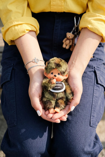 Lifestyle hand-hold shot of camo plush doll keychain 8ttitto8, gift-ready with original hang tag, Y2K plush charm aesthetic.