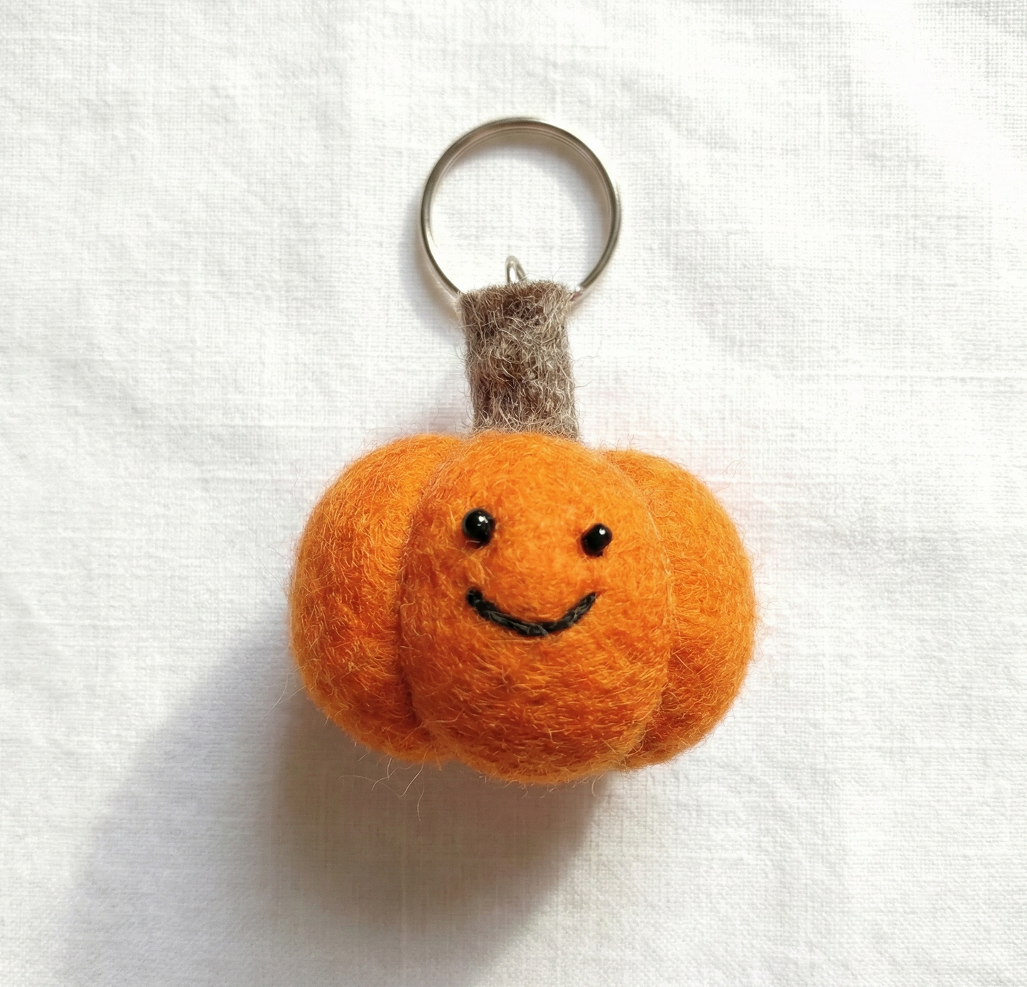 Orange pumpkin felt keychain with brown stem detail