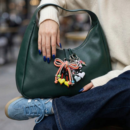Green hobo bag with orange multicolor rope bow charm and yellow white heart pendants