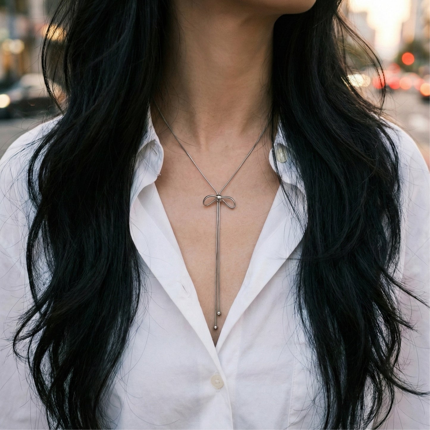 Silver bow Y-necklace with pearl choker layering - sophisticated minimal jewelry styling