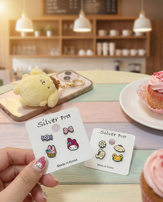 Sanrio character earring sets on cards with My Melody and Pompompurin designs in cafe setting