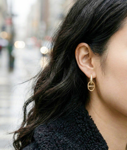 Outdoor lifestyle shot of gold anchor link huggie earrings