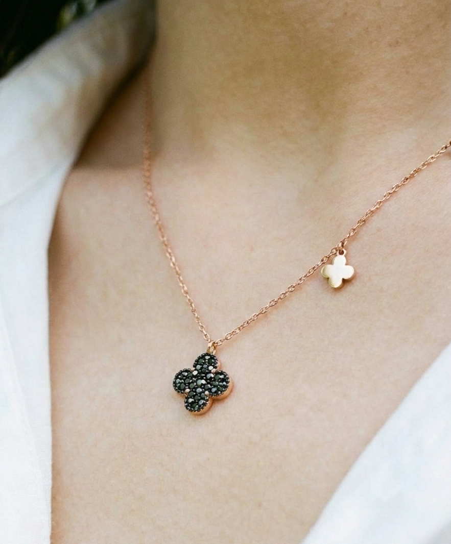 Cognac brown clover pendant necklace worn on neck with white top – dainty rose gold chain with off-center mini clover charm