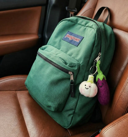 Handmade Nepal wool felt vegetable keychain set hanging on navy blue backpack