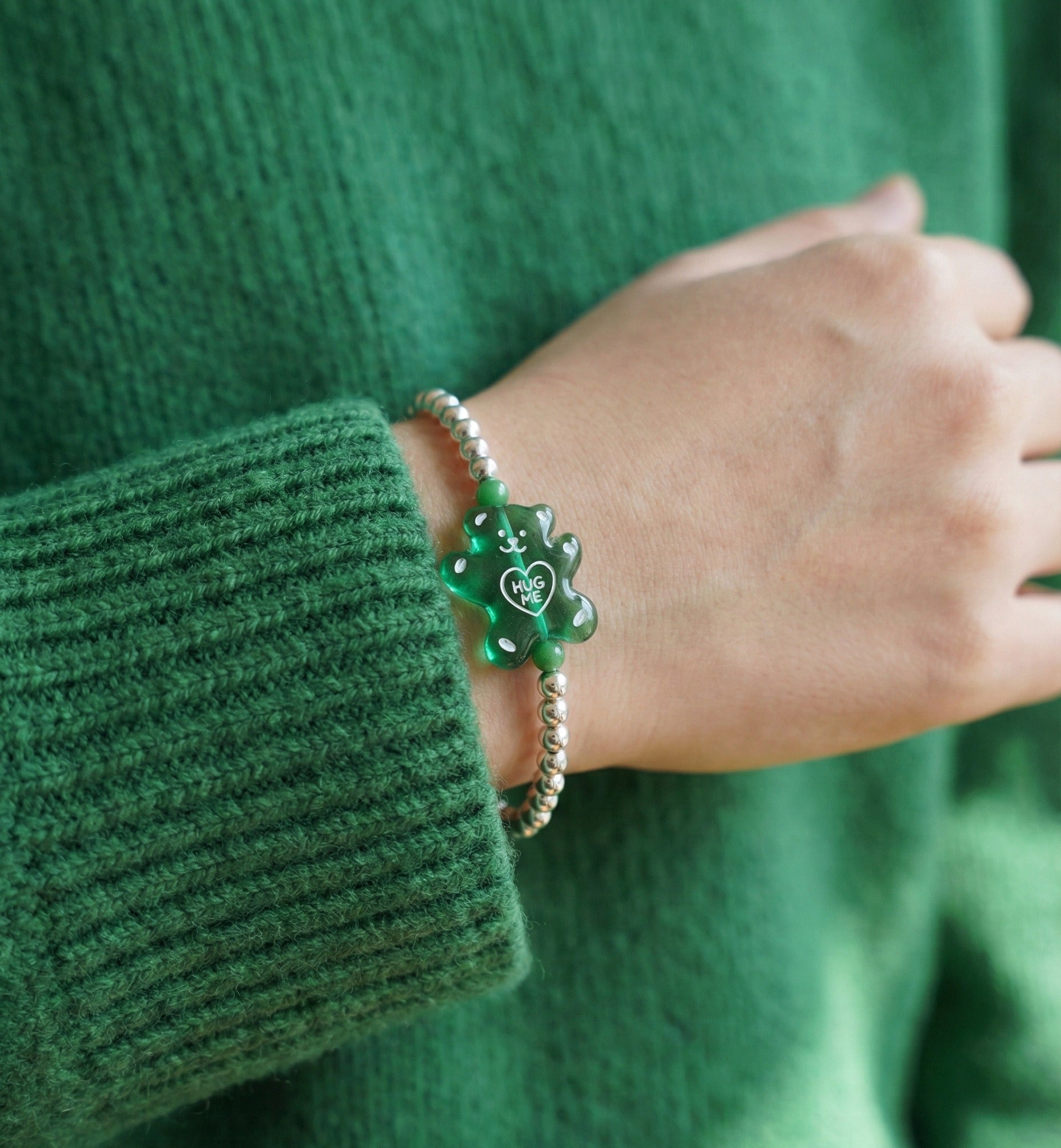 	Green jelly gummy bear 925 sterling silver bracelet on wrist with green ribbed knit sleeve