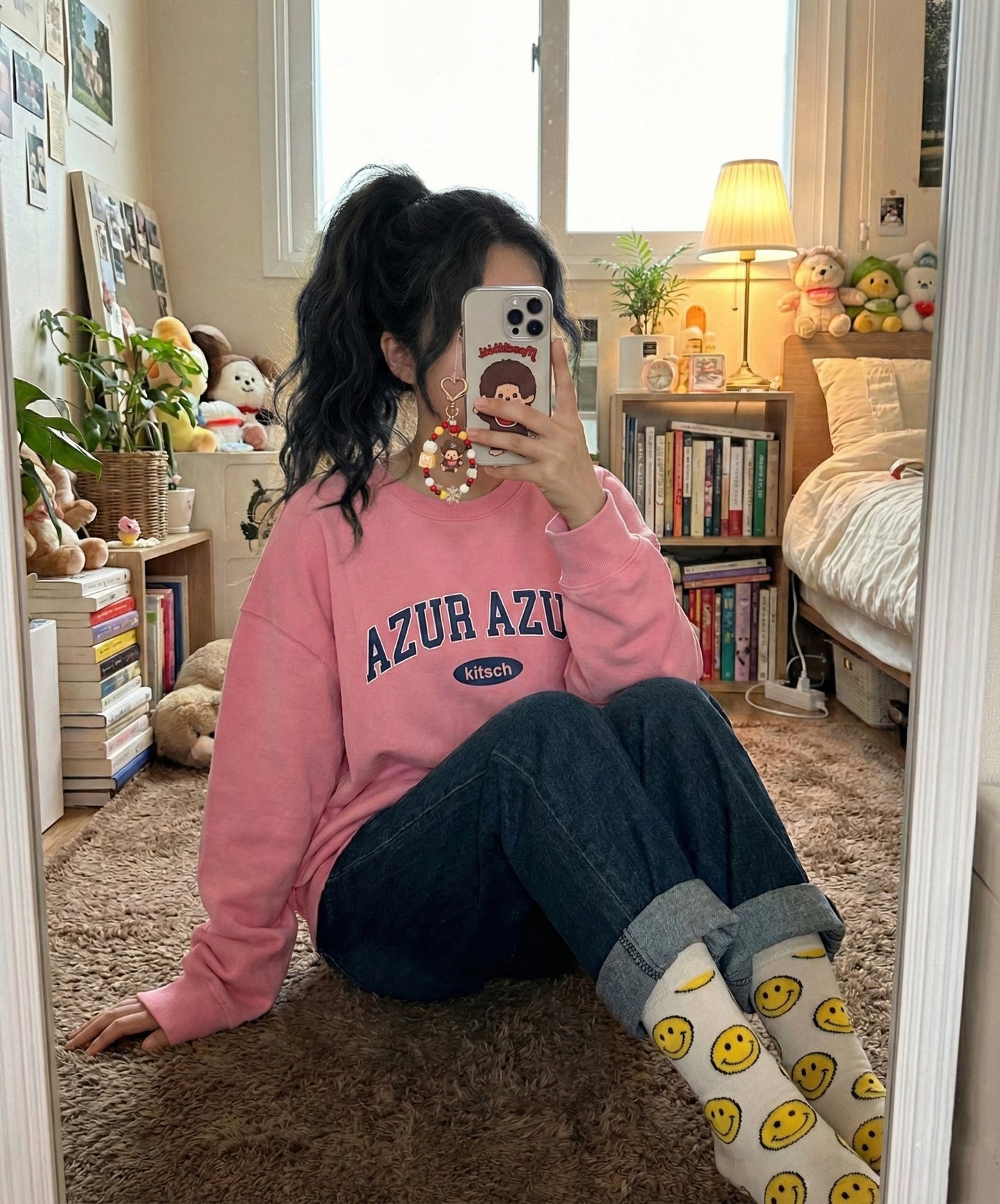 Asian woman taking mirror selfie in bedroom showing Monchhichi beaded phone strap attached to iPhone case, Y2K aesthetic room decor
