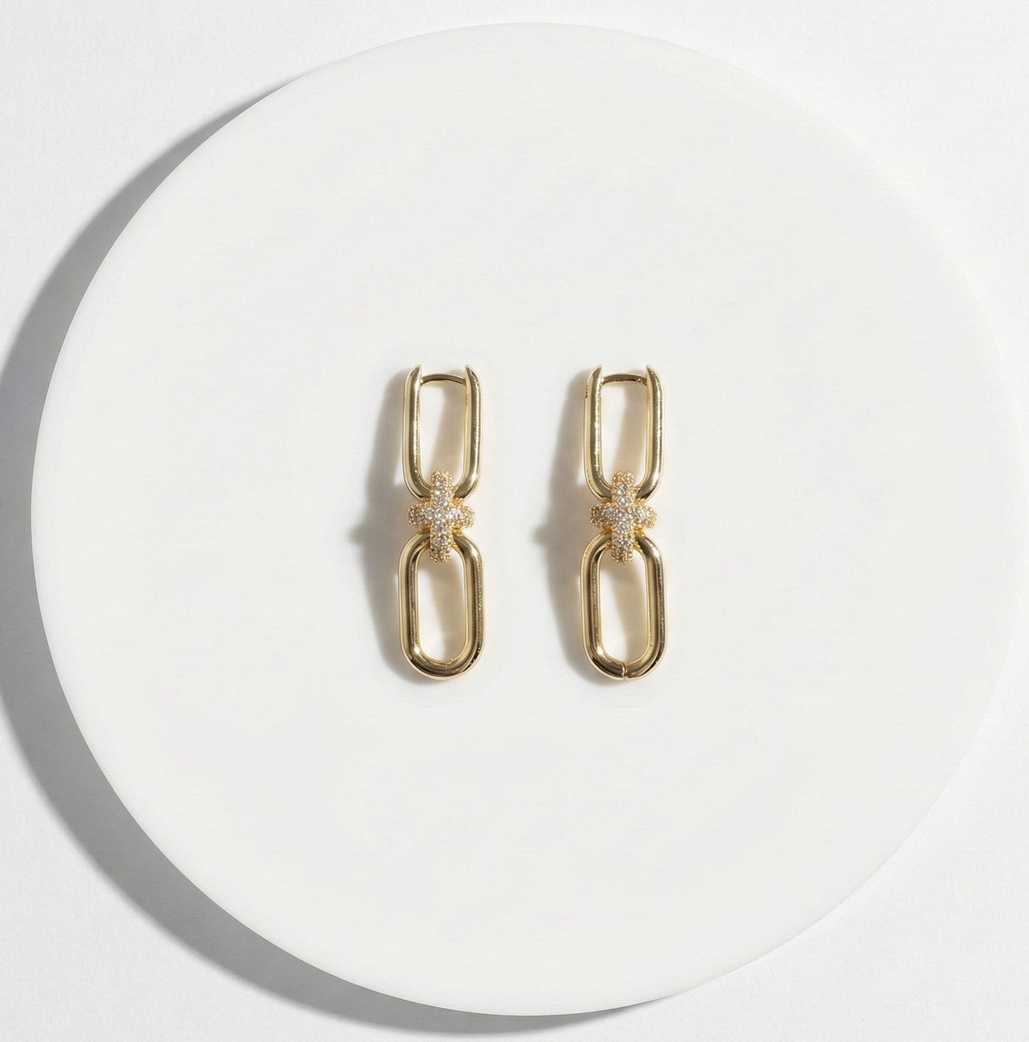 Flat lay of gold chain knot earrings on white background, jewelry product photography