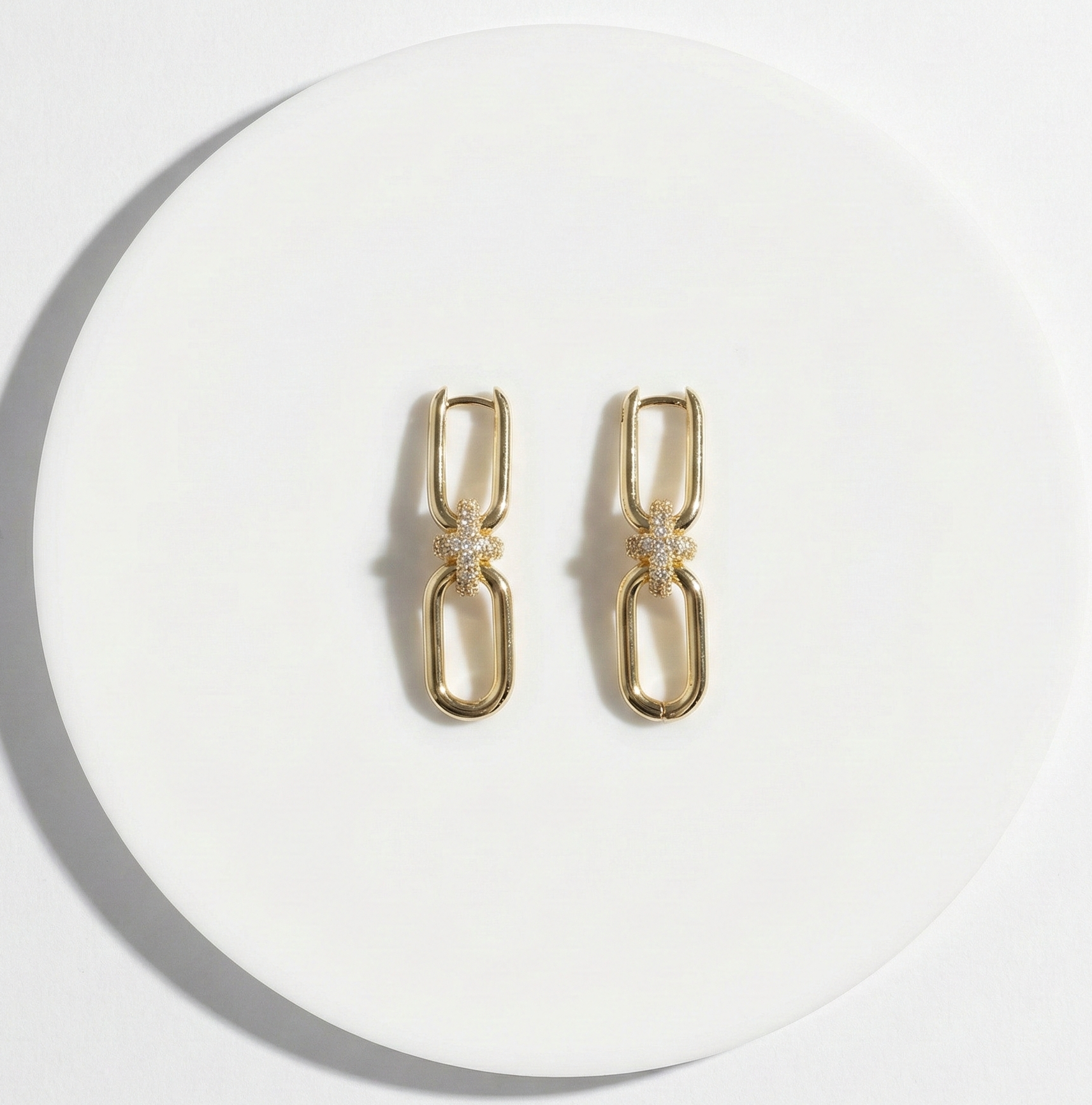  Flat lay of gold chain knot earrings on white background, jewelry product photography