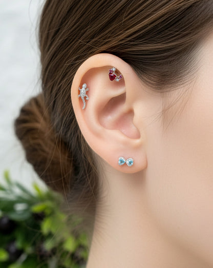Close-up of an ear with multiple earrings against a blurred background