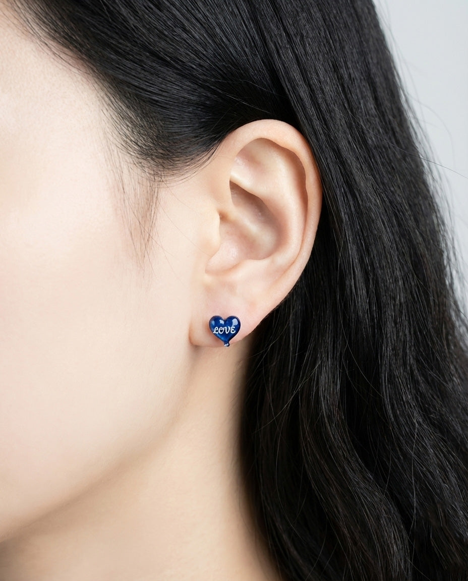 Side profile of woman wearing royal blue heart balloon stud earring