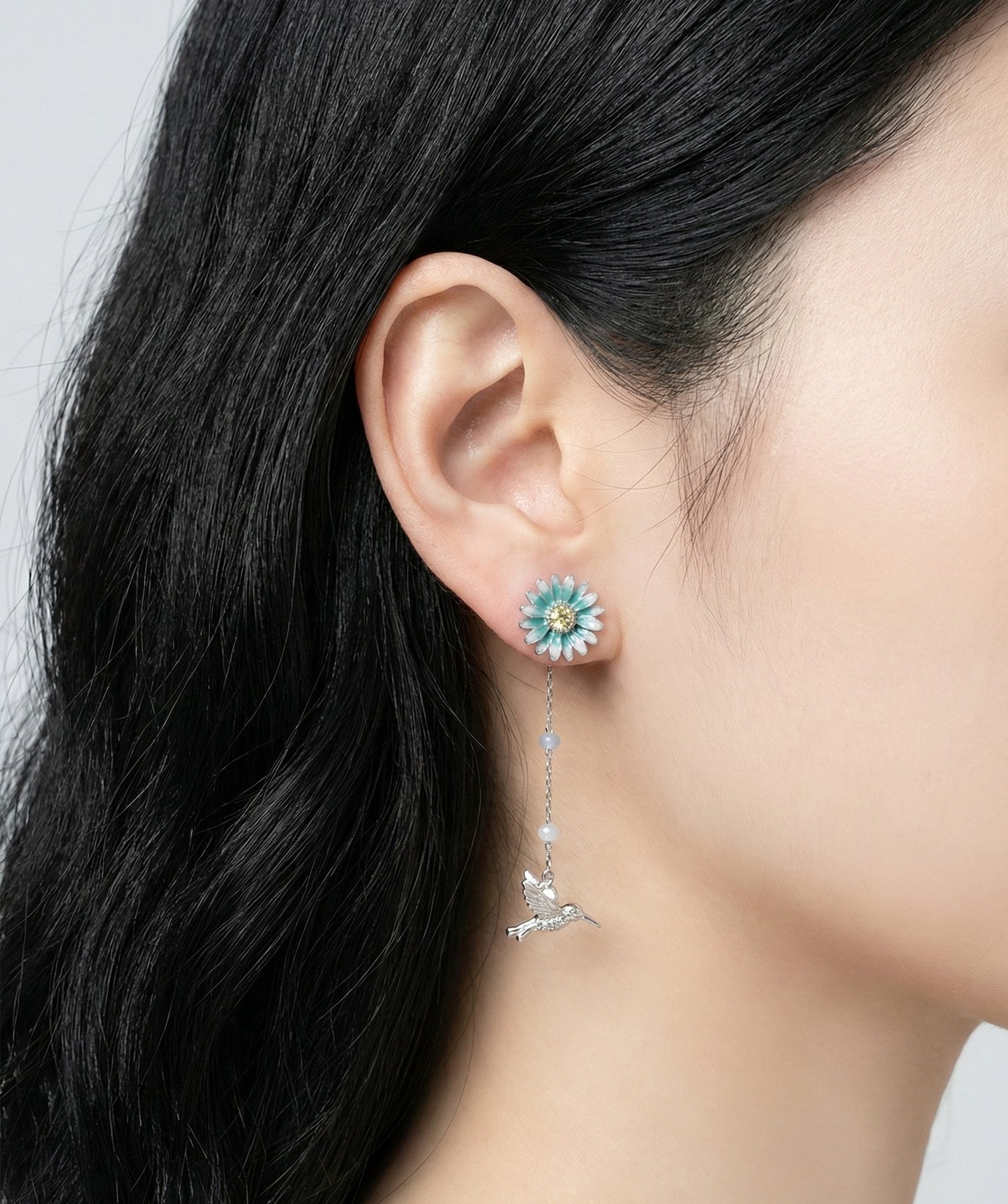Profile view of model showing silver earring drop length and design